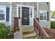 Close-up of the front door with stone accents, the house number, and a small porch at 6020 Running Deer Rd, Charlotte, NC 28214