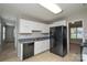 Kitchen features white cabinets, black appliances, and tiled floors at 6020 Running Deer Rd, Charlotte, NC 28214