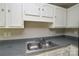 Kitchen features white cabinets and a stainless steel sink at 6020 Running Deer Rd, Charlotte, NC 28214
