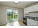 Kitchen features white cabinets, stainless steel sink, and a backyard view at 6020 Running Deer Rd, Charlotte, NC 28214
