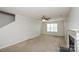 Spacious living room with a fireplace, neutral carpet, ceiling fan and a large window at 6020 Running Deer Rd, Charlotte, NC 28214