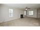 Spacious living room with a fireplace, neutral carpet, and lots of natural light at 6020 Running Deer Rd, Charlotte, NC 28214