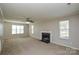 Spacious living room with a fireplace, neutral carpet, ceiling fan and many windows at 6020 Running Deer Rd, Charlotte, NC 28214