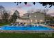 Twilight view of backyard, swimming pool, hot tub, furniture, screened-in porch, and landscaped yard at 6147 Lake Providence Ln, Charlotte, NC 28277