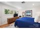 Bright bedroom featuring hardwood floors, light-colored walls, natural light, and a large wooden cabinet at 6147 Lake Providence Ln, Charlotte, NC 28277