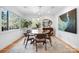Bright dining room featuring a modern glass table set, complemented by a large window and stylish decor at 6147 Lake Providence Ln, Charlotte, NC 28277