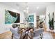 Dining room with a glass-top table, six gray chairs, modern lighting, and unique artwork at 6147 Lake Providence Ln, Charlotte, NC 28277
