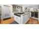 Modern kitchen boasts a large island with a stainless steel cooktop and white cabinetry at 6147 Lake Providence Ln, Charlotte, NC 28277