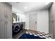 Laundry room has a washer and dryer, storage cabinets, and black and white flooring at 6147 Lake Providence Ln, Charlotte, NC 28277