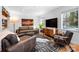 Living room with hardwood floors, leather furniture and a large TV at 6147 Lake Providence Ln, Charlotte, NC 28277