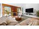Inviting living room boasts a wood accent wall, fireplace, and large windows, complete with modern furnishings at 6147 Lake Providence Ln, Charlotte, NC 28277