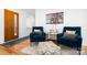 Cozy sitting area with stylish blue armchairs, a patterned rug, and artwork, offering a comfortable space at 6147 Lake Providence Ln, Charlotte, NC 28277