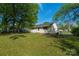 Backyard of home with large trees on a sunny day, creating a peaceful retreat at 619 Center St, Gastonia, NC 28054
