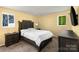 Comfortable bedroom features a tufted headboard, soft carpet, and natural light from two windows at 619 Center St, Gastonia, NC 28054