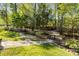 A beautifully landscaped backyard featuring stone pathways and lush greenery at 7798 Sand Trap Ln, Stanley, NC 28164