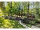Backyard with beautiful, well maintained landscaping and a stone path through the trees at 7798 Sand Trap Ln, Stanley, NC 28164