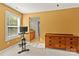 Bright bedroom featuring an exercise bike, dresser, and adjacent bathroom access for added convenience at 7798 Sand Trap Ln, Stanley, NC 28164