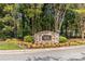 Stone sign for 'Tree Tops' community surrounded by colorful flowers and greenery at 7798 Sand Trap Ln, Stanley, NC 28164