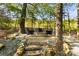 Backyard fire pit with seating surrounded by trees at 7798 Sand Trap Ln, Stanley, NC 28164