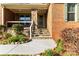 Brick home with a charming front porch featuring a stone pillar and well-kept landscaping at 7798 Sand Trap Ln, Stanley, NC 28164
