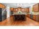 Modern kitchen with stainless steel appliances, granite countertops, a central island and hardwood floors at 7798 Sand Trap Ln, Stanley, NC 28164
