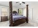 Main bedroom featuring a dark wood four-poster bed, soft carpeting, and plenty of natural light at 7798 Sand Trap Ln, Stanley, NC 28164