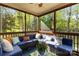 Inviting screened porch with comfortable seating and lush greenery, ideal for outdoor relaxation and entertaining at 7798 Sand Trap Ln, Stanley, NC 28164