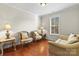 Comfortable sitting room with hardwood floors, natural light from a window, and stylish furniture at 7798 Sand Trap Ln, Stanley, NC 28164