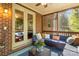 Cozy screened porch with comfortable seating and brick wall at 7798 Sand Trap Ln, Stanley, NC 28164