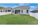 Spacious backyard featuring a lush lawn, a covered patio, and a white vinyl fence for privacy at 7850 Fountaingrass Ln, Sherrills Ford, NC 28673