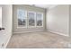 Well-lit bedroom featuring plush carpet, neutral walls, and three large windows at 7850 Fountaingrass Ln, Sherrills Ford, NC 28673