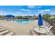 Community pool with lounge chairs, tables and umbrellas, set against a backdrop of mature trees and blue skies at 7850 Fountaingrass Ln, Sherrills Ford, NC 28673
