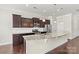 Open kitchen showcasing a large granite countertop island, stainless appliances, and dark wood cabinets at 7850 Fountaingrass Ln, Sherrills Ford, NC 28673