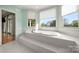 Bright bathroom with a soaking tub situated beneath large windows offering picturesque views at 7980 Bradford Ln, Denver, NC 28037
