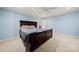 A bedroom with light blue walls and dark wood accents presents a serene and inviting space at 7980 Bradford Ln, Denver, NC 28037
