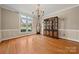 Bright dining room with hardwood floors, a chandelier, and a large window offering natural light at 7980 Bradford Ln, Denver, NC 28037