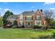 Elegant brick home featuring a manicured lawn and garden, complemented by classic architectural details at 7980 Bradford Ln, Denver, NC 28037