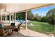 Covered patio featuring a dining area and firepit with seating overlooks a lush yard and inviting pool at 7980 Bradford Ln, Denver, NC 28037