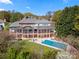 Expansive two-story back porch overlooking a swimming pool, surrounded by lush greenery and mature trees at 7980 Bradford Ln, Denver, NC 28037