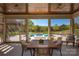 Inviting covered patio with a dining table and a clear view of the sparkling pool and lush landscaping at 819 Beauhaven Ln, Waxhaw, NC 28173