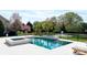 A gorgeous pool with a water feature and hot tub overlooking a pond is perfect for relaxing and entertaining guests at 819 Beauhaven Ln, Waxhaw, NC 28173