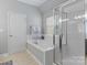 Bright bathroom with soaking tub next to shower and window; tiled floor at 8311 Camberly Rd, Huntersville, NC 28078