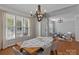 Bright dining room featuring hardwood floors, a wooden table, and open access to the living room and foyer at 8311 Camberly Rd, Huntersville, NC 28078