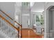 Bright foyer with hardwood floors, staircase, and natural light filtering through the large front windows at 8311 Camberly Rd, Huntersville, NC 28078