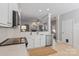 Open kitchen with stainless steel appliances, white cabinets, and view into the living room with fireplace at 8311 Camberly Rd, Huntersville, NC 28078