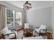 Cozy living room featuring hardwood floors, neutral walls, and four comfortable white armchairs around a coffee table at 8311 Camberly Rd, Huntersville, NC 28078