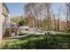A backyard featuring an in-ground pool, surrounded by a stone patio, lush greenery and mature trees at 8718 Canter Post Dr, Charlotte, NC 28216