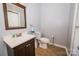 Traditional bathroom featuring a wood vanity, toilet, and mirror at 8718 Canter Post Dr, Charlotte, NC 28216