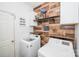 Functional laundry room with wood accent wall, front-load machines, and storage shelves at 8718 Canter Post Dr, Charlotte, NC 28216
