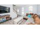 Inviting living room featuring a large sectional sofa, arched windows, and a staircase, flooded with natural light at 8718 Canter Post Dr, Charlotte, NC 28216